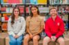 Girl wearing gray quarter zip, guy wearing a tan tee, and guy wearing a red quarter zip